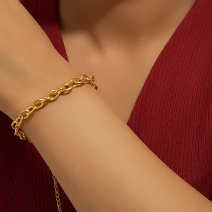 A gold chain bracelet with an adjustable extender and a small heart charm.