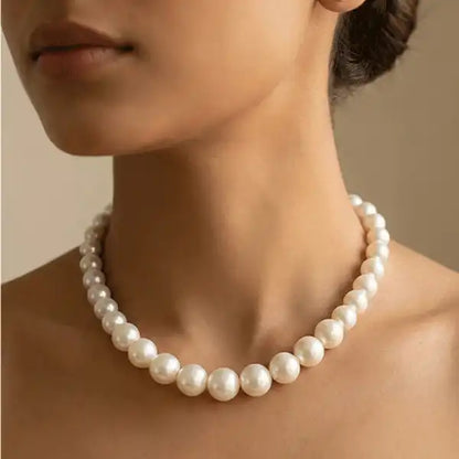 Classic round pearl necklace worn close to neck on model