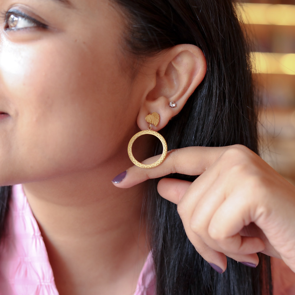 Golden Aura Hoops glow with a smooth, radiant finish.